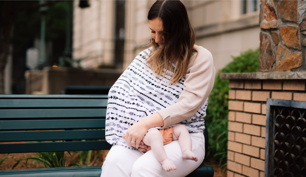 Mama nursing her in public with a cover over her baby